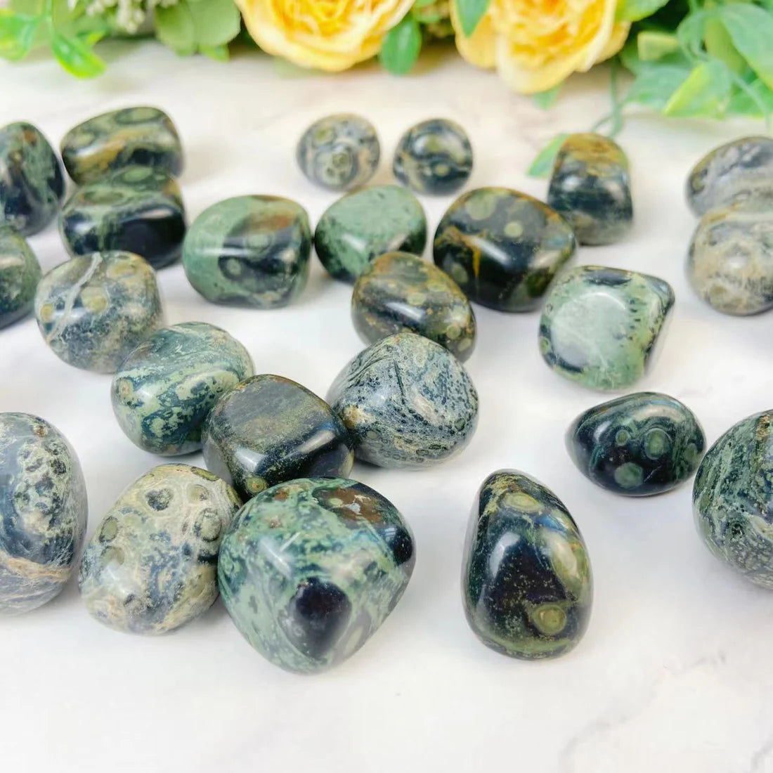 A set of Kabamba jasper tumbled stones with marbled swirls of sage green and beige on black.