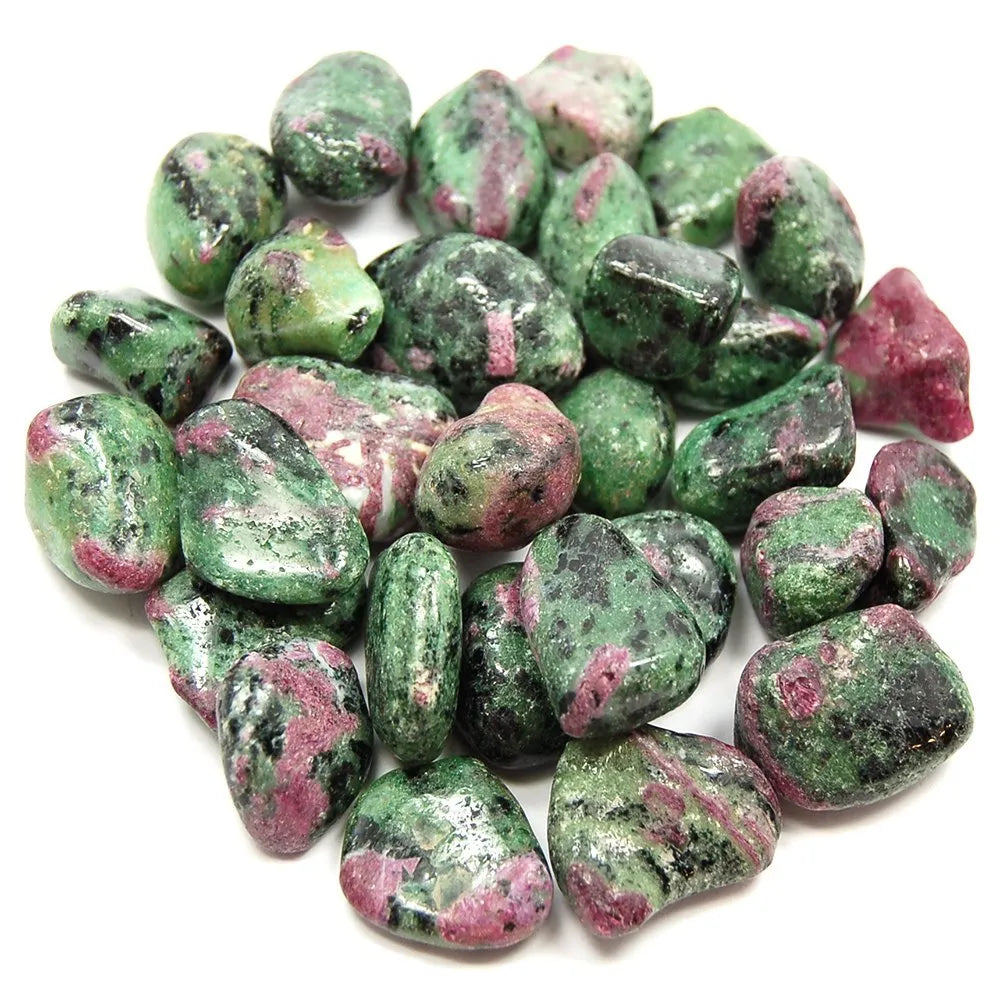 Several ruby zoisite crystal tumbled stones in a pile.