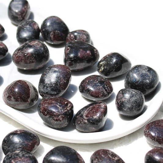 Garnet tumbled stones in black with brown-red patches.